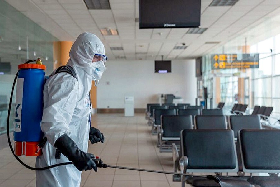 Persona realizando desinfección de instalaciones de un aeropuerto