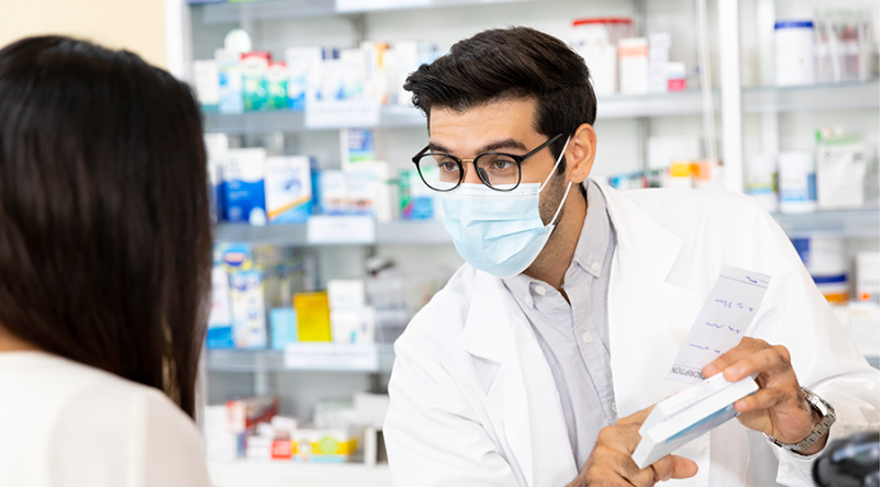 Farmacéutico explicando tratamiento medico a persona